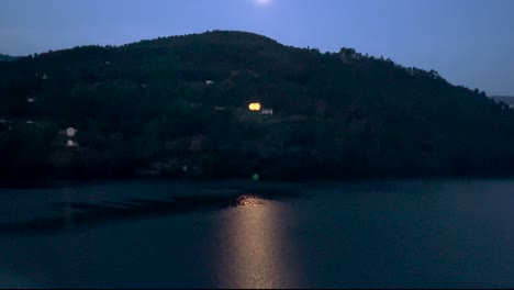 bright moon reflecting in calm river water, europe night