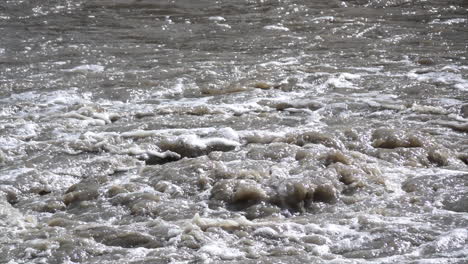 Silt-laden hot spring water roils and boils in slow motion at Yellowstone National Park