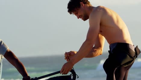 Male-surfer-preparing-windsurfer-in-the-beach-4k