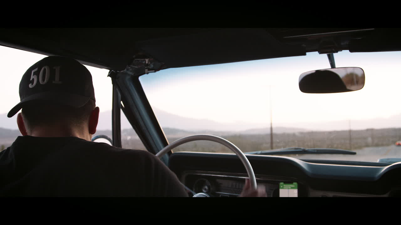 젊은 남자가 차를 돌리고 고속도로로 운전, 뒷면