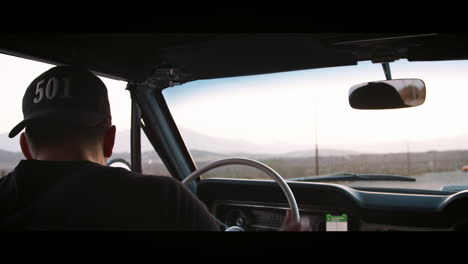 joven girando el coche y conduciendo en la autopista, vista trasera