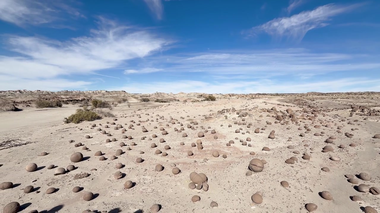 Cancha de Bochas no Parque Provincial Ischigualasto, Valle de la Luna, San Juan, Argentina, apresentando concreções esféricas de arenito em uma paisagem desértica árida sob um céu azul