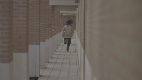 person running through a brick corridor