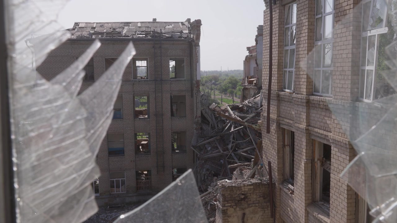 Una vista dalla finestra delle rovine di una scuola ucraina distrutta dalla guerra.