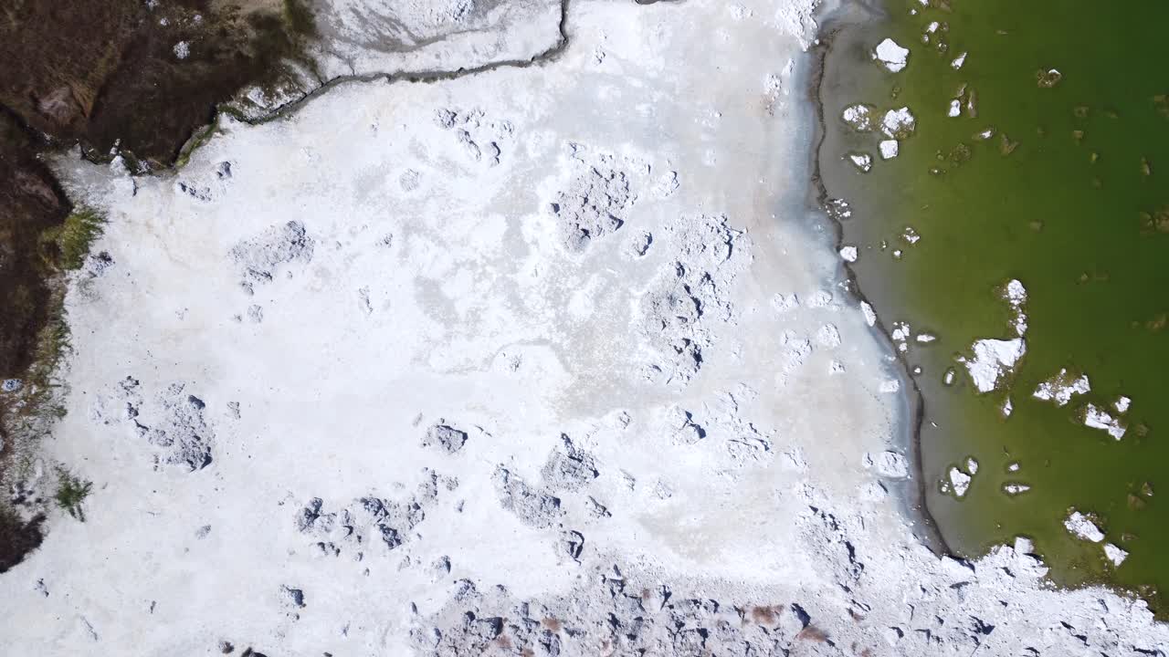 Bird's eye view of a lake shore, moving upwards.