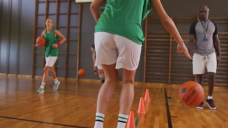 diverse female basketball team and coach practice dribbling ball