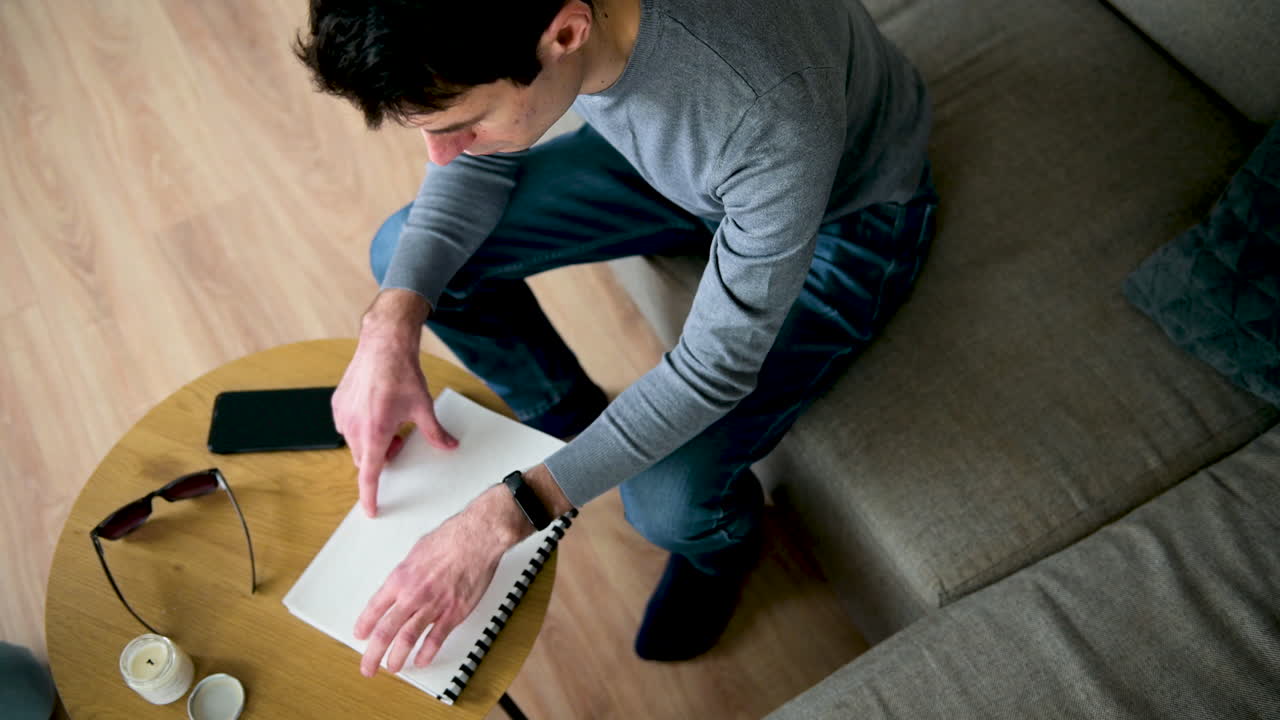 Blind Man Reading A Braille Book While Sitting On Sofa At Home 2