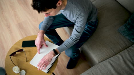 Blind-Man-Reading-A-Braille-Book-While-Sitting-On-Sofa-At-Home-2