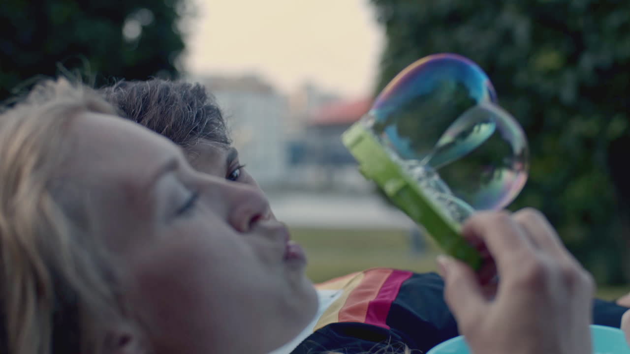 Una pareja soplando burbujas en el parque.