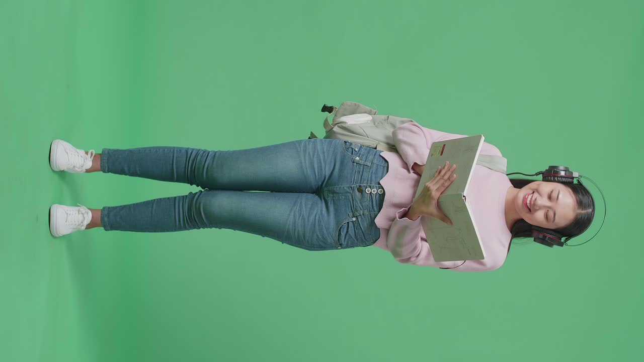 estudiante leyendo con auriculares y mochila
