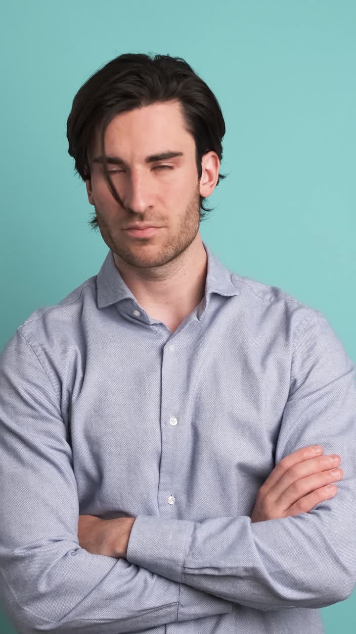Disagreeing adult man shaking head in blue studio