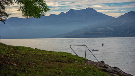 man sitting on lake shore, contemplating, then leaving, timelapse