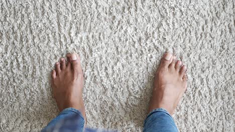 persona descalza de pie en la alfombra