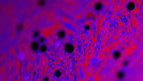 pink and purple-colored liquid from soap's surface: macro shot