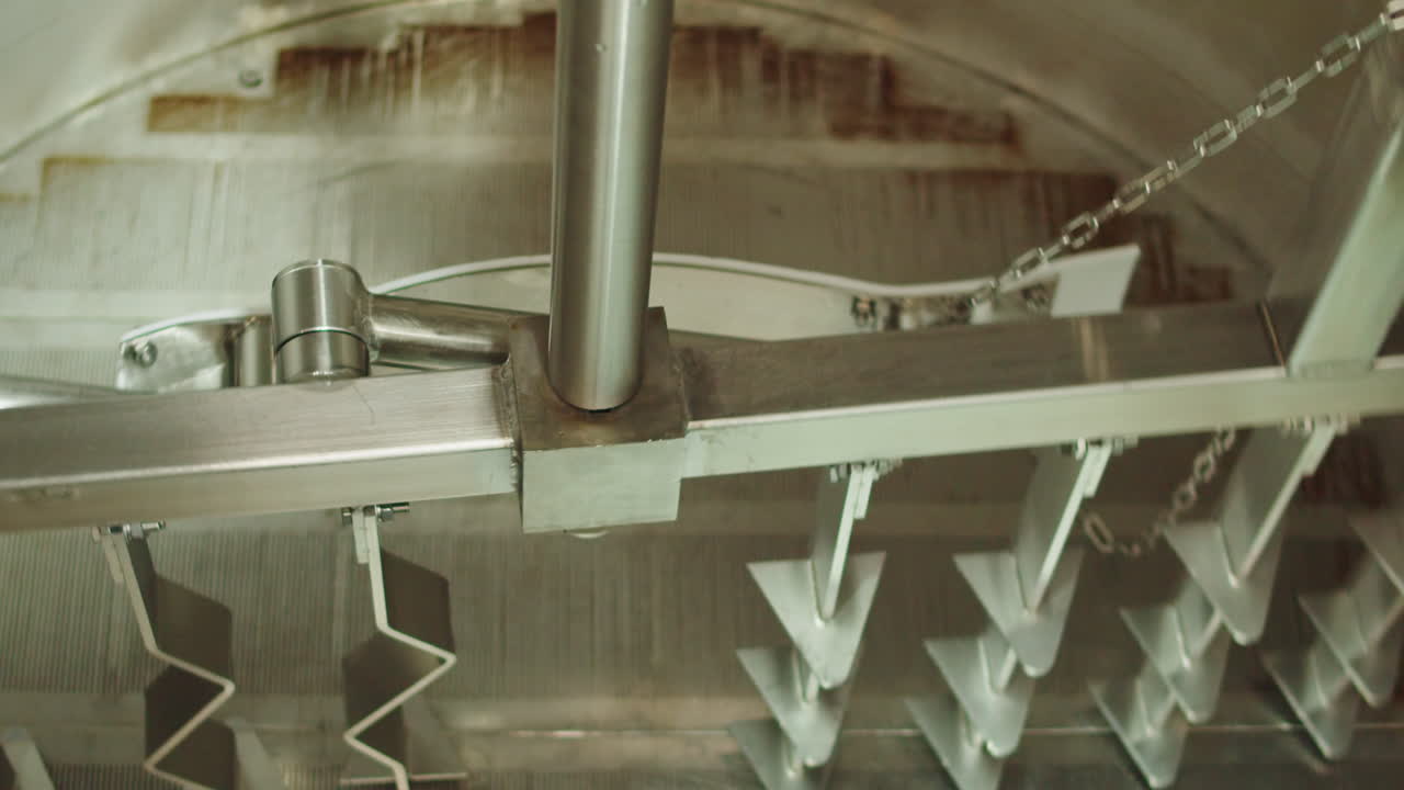 Craft beer production factory, brewery manufacture. Putting barley malt grains in conveyor close-up. Brewing, cooking alcohol in metal vats bottles