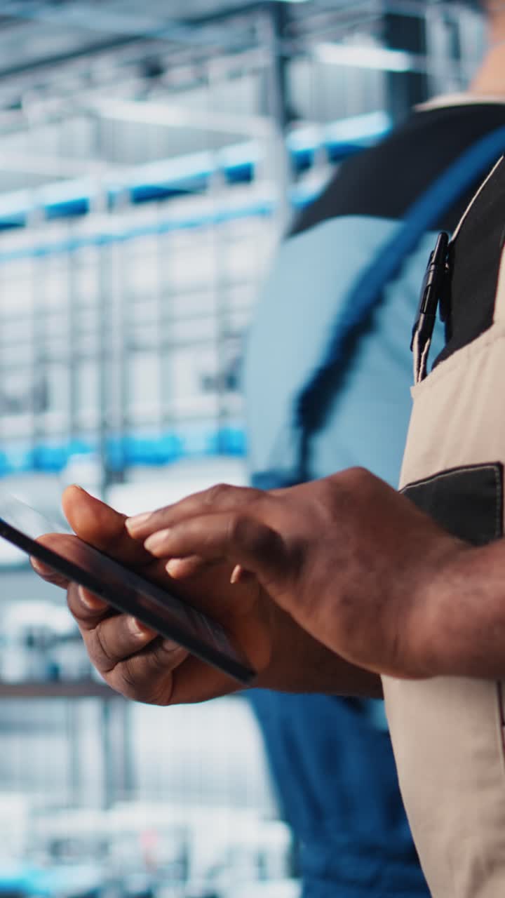 Vertical video Smart factory expert using digital device app to test automated systems, closeup