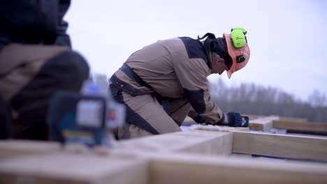 carpenter installing wooden beams