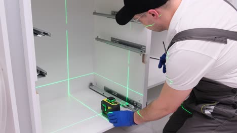 installation of kitchen accessories using a construction laser
