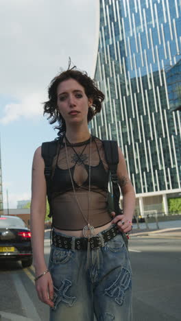 Vertical-Video-Outdoor-Fashion-Portrait-Of-Young-Alternative-Style-Woman-With-Tattoos-And-Piercing-Standing-Outside-Modern-Buildings-At-Canary-Wharf-London-Shot-In-Real-Time-3