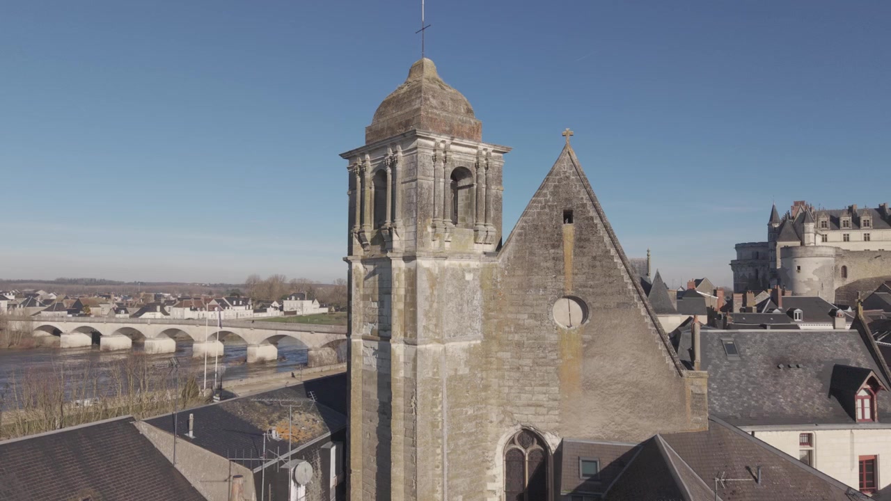 Uma vista aérea mostra uma torre de igreja colegiada de pedra erguendo-se ao lado das muralhas da cidade perto do Castelo de Amboise.