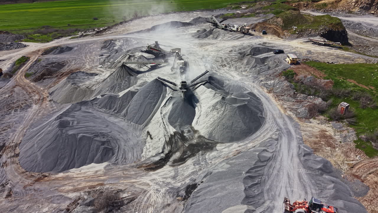 Penambangan granit beroperasi dengan alat berat bekerja di siang hari di lanskap terbuka