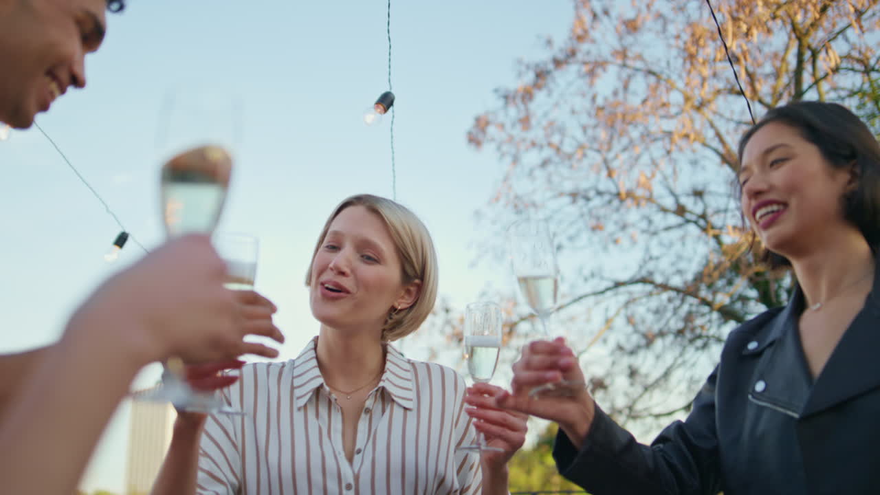 파티오 클로즈업에서 함께 축하하는 흥분한 회사. 친구들이 걱거리는 컵