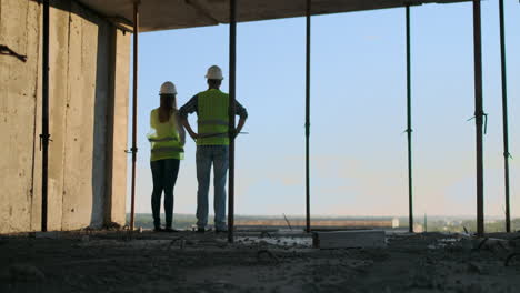 Architektin-Und-Bauarbeiter-Auf-Der-Baustelle,-Rückansicht.-Teamarbeit-Bei-Der-Gebäudeentwicklung-Und-Mitarbeiterkonzept.-Architektin-Und-Bauarbeiter-Auf-Der-Baustelle