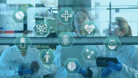 medizinische ikonen gegen eine gruppe von wissenschaftlern, die im labor arbeiten