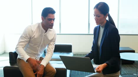 business colleagues discussing over laptop