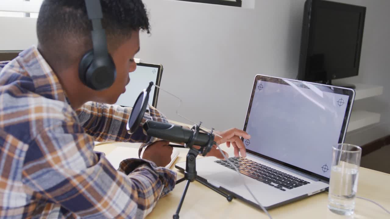African american male teenage boy recording podcast using laptop with copy space, slow motion
