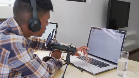 African-american-male-teenage-boy-recording-podcast-using-laptop-with-copy-space,-slow-motion