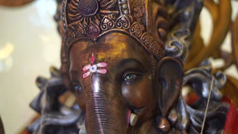 estatua de ganpati del dios indio cara de cámara lenta de piedra oscura de cerca