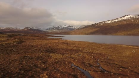 A-flight-over-the-Northern-Scottish-highlands-with-mountains-and-lakes-at-sunset