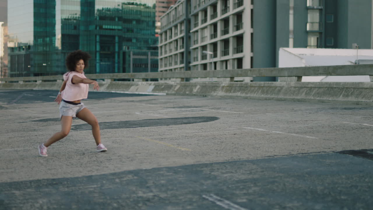 mujer bailarina joven bailarina de raza mixta realizando baile callejero de estilo urbano en la ciudad practicando movimientos de estilo libre mujer de moda con afro