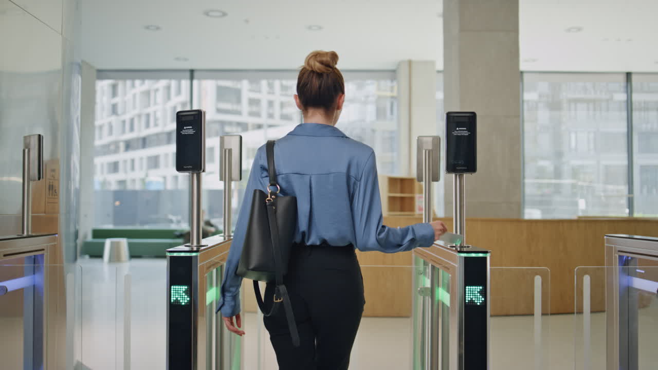 자신감 있는 여성이 사무실을 떠나고 회전문으로 걸어가고 있습니다. 뒤쪽을 바라보는 사업가 여성이 가고 있습니다.