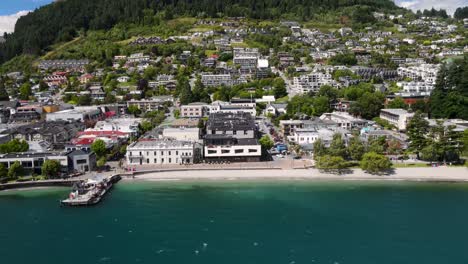 frente a la playa del lago wakatipu en queenstown, revelación aérea a la colina