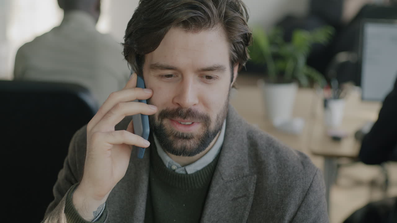 사무실에서 전화 통화를 하는 사업가