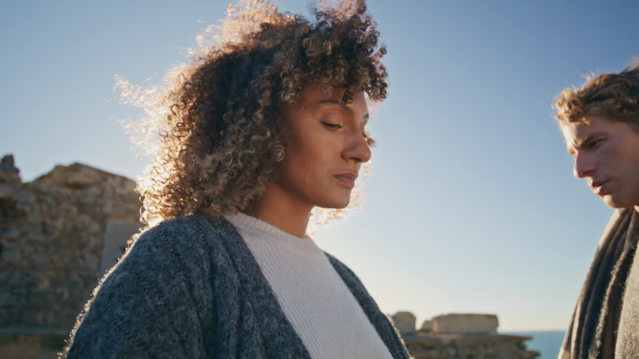 Upset models standing sunset beach closeup. Multiracial man woman contemplating