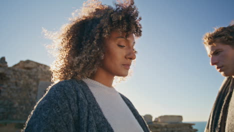 upset models standing sunset beach closeup. multiracial man woman contemplating