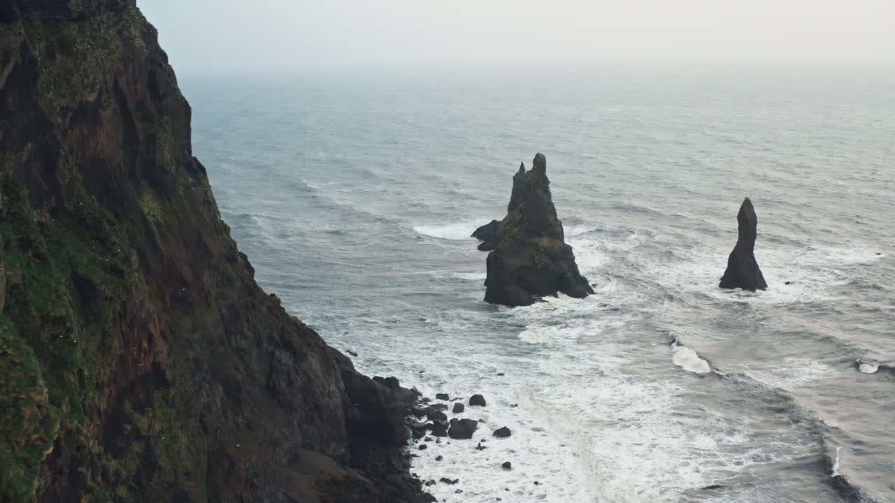 tomada aérea cinematográfica de la playa de arena negra de reynisfjara, vik - islandia