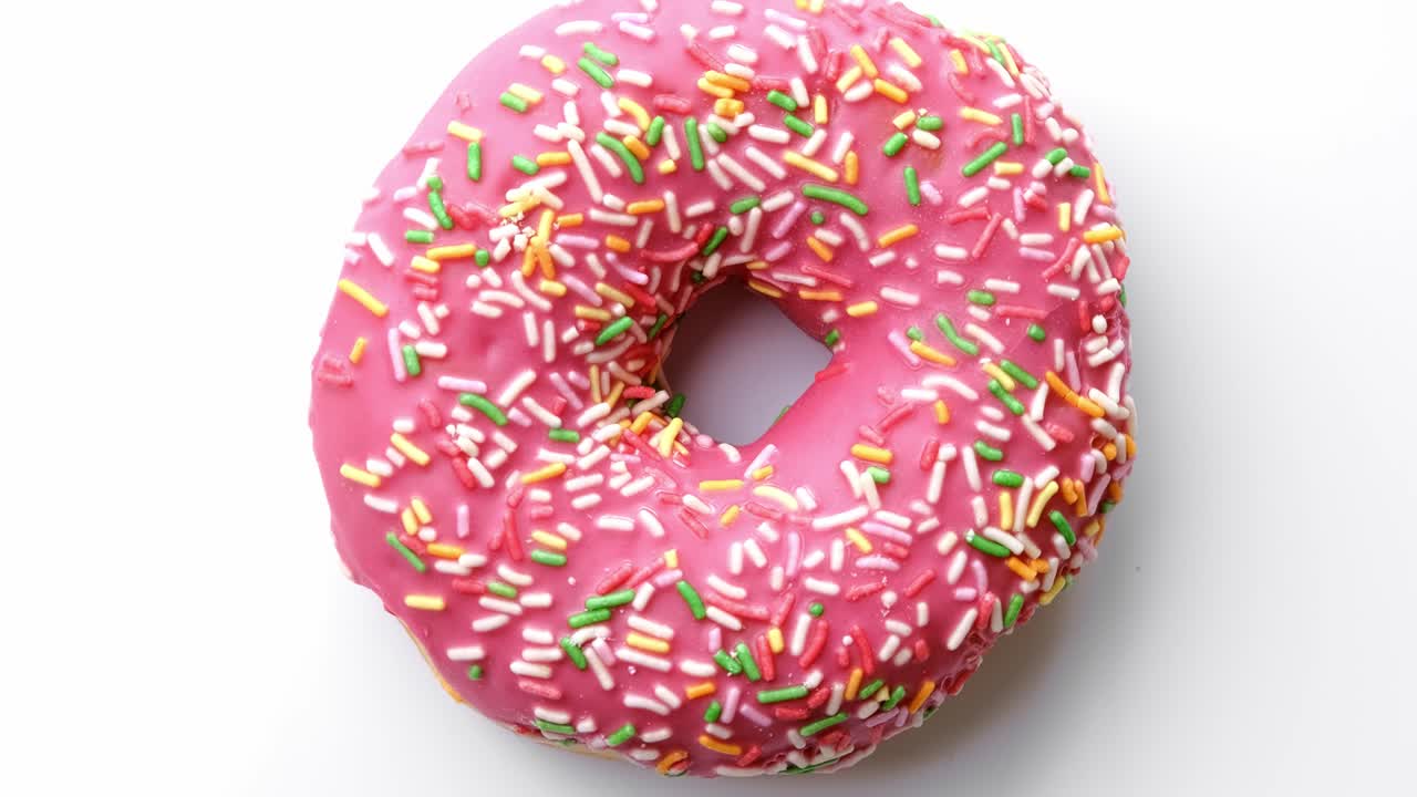primer plano increíble colorido anillo de rosquilla dulce cubierto de glaseado rosado. disparado con cámara roja en 4k