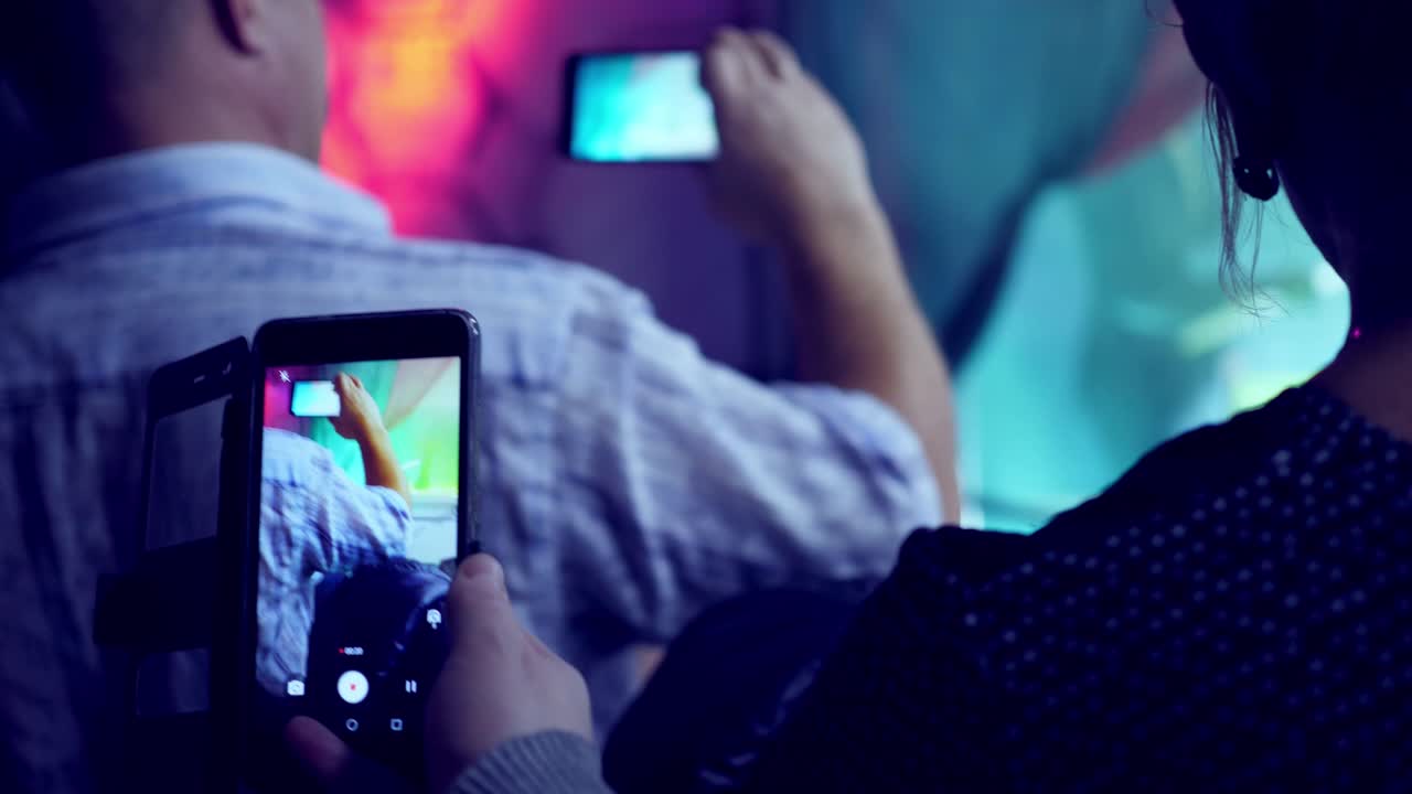 People recording video at a show