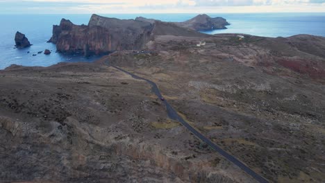 El-Coche-Circula-Por-Una-Sinuosa-Carretera-De-Montaña,-Con-Impresionantes-Vistas-De-La-Costa-Del-Océano-Y-Un-Cielo-Azul.