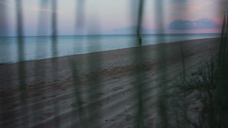 silhouette woman walking sand beach at cold morning sunrise dusk. alone girl