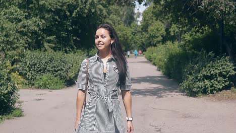 Una-Mujer-Joven-Y-Bonita-Vestida-De-Verano-Camina-Por-El-Callejón-Del-Parque