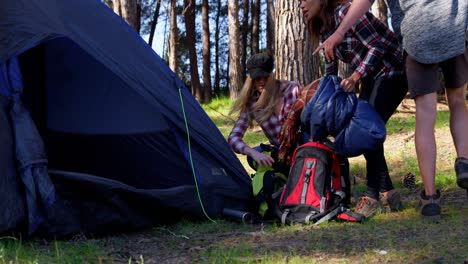 friends setting up tent in the forest on a sunny day 4k