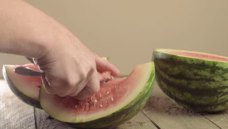 hand spooning out a juicy ripe watermelon