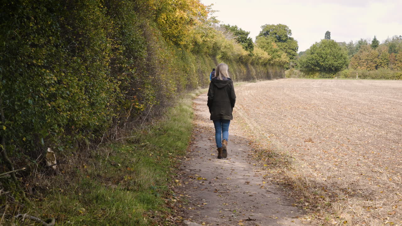 A woman walking along a path in the countryside