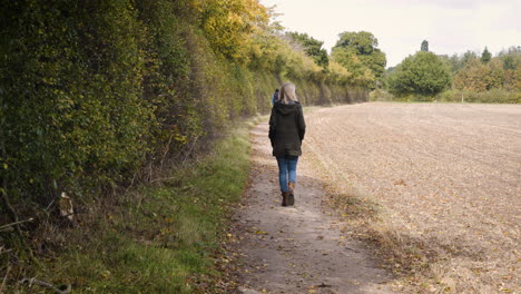 a woman walking along a path in the countryside