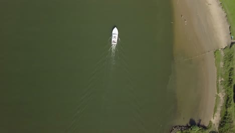 aerial drone view of top-down shot following the boat at the meuse river in the netherlands, europe